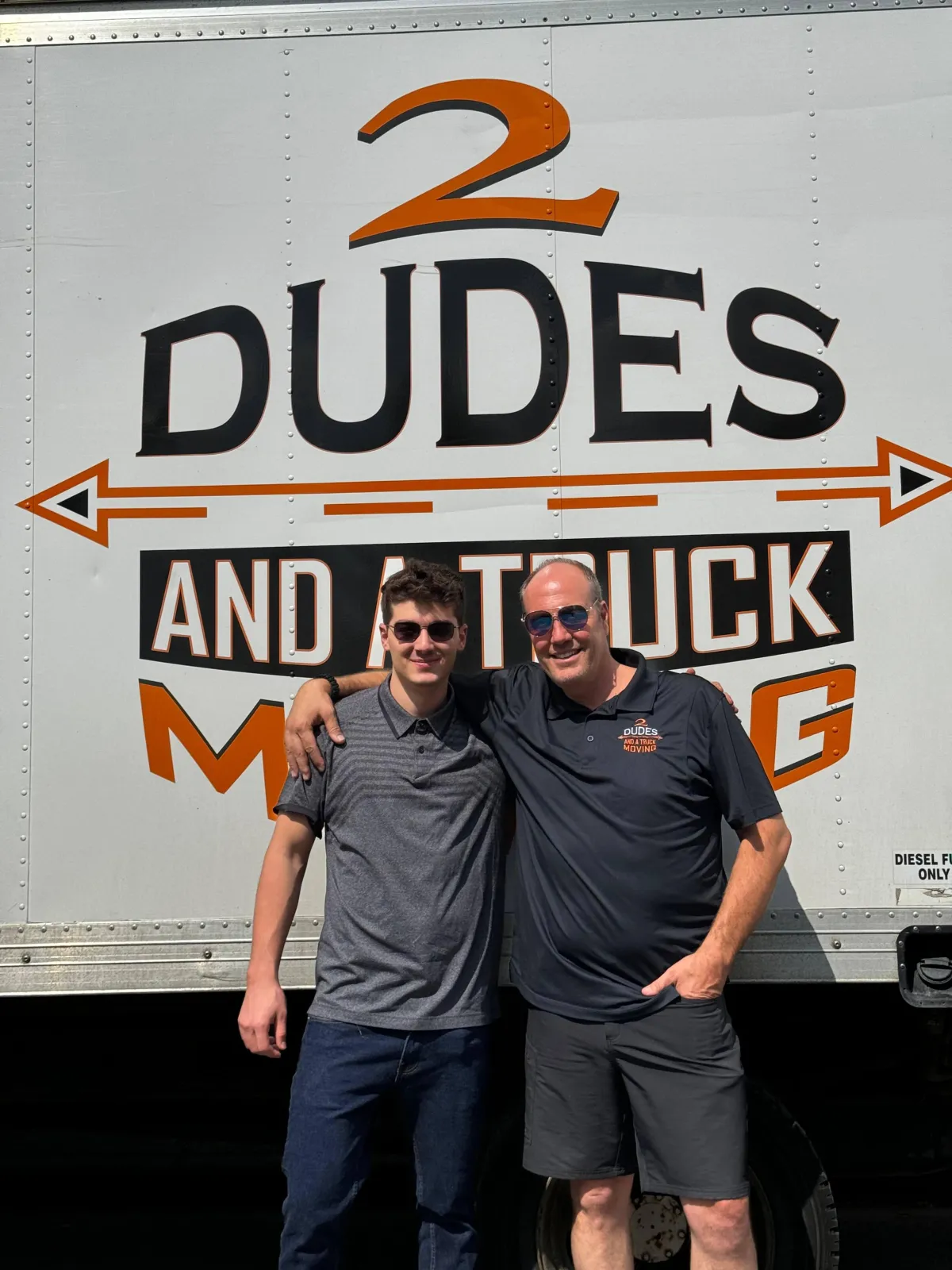 Janzen with his father in front of a 2 Dudes And A Truck moving truck